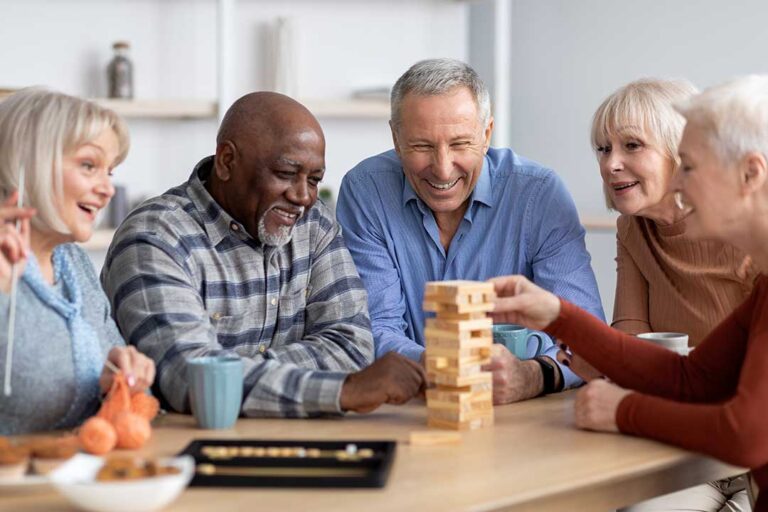 An older adult reviewing a checklist with a family member and staff in a comfortable living room.